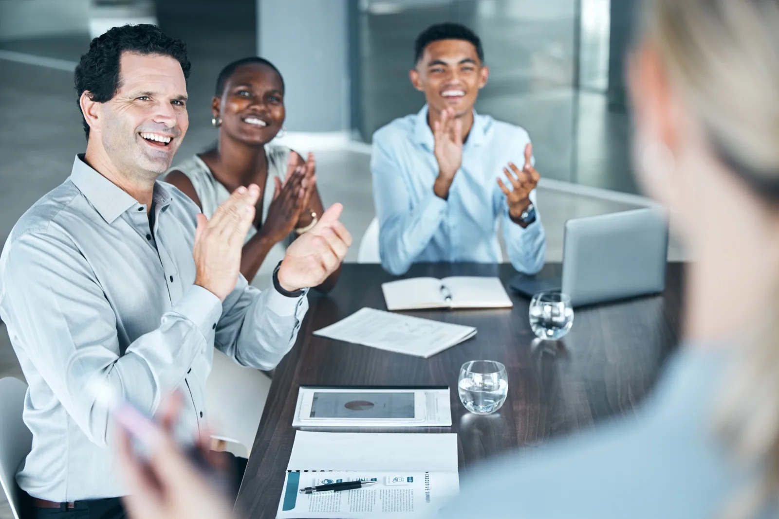 Corporate team applauding in boardroom meeting